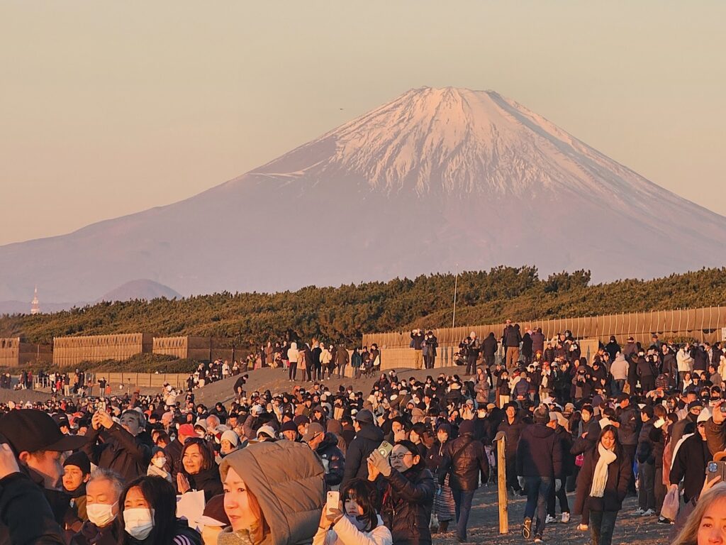 初日の出とともに輝く2025年の富士山と初詣の人々