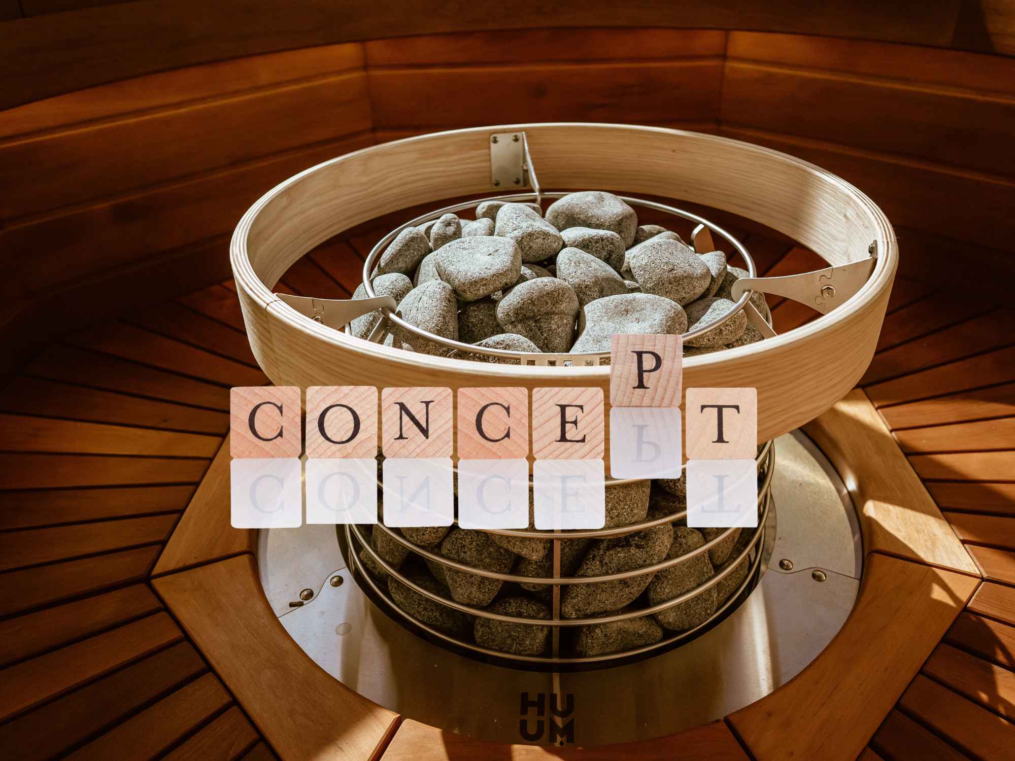 サウナストーブに設置されたサウナストーンと木製の囲い枠の上に「CONCEPT」の文字が配置されたデザイン画像
