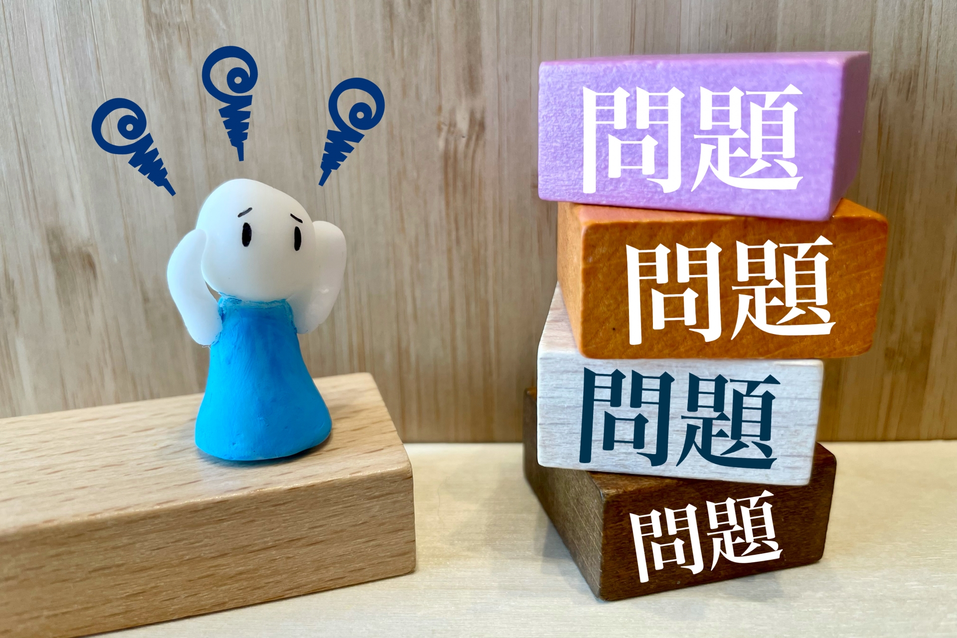 困った表情のキャラクターと「問題」と書かれた積み木の山