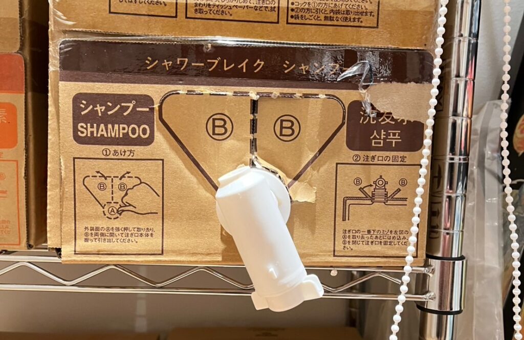 業務用シャンプーの段ボールに取り付けられた白い注ぎ口と使用説明図