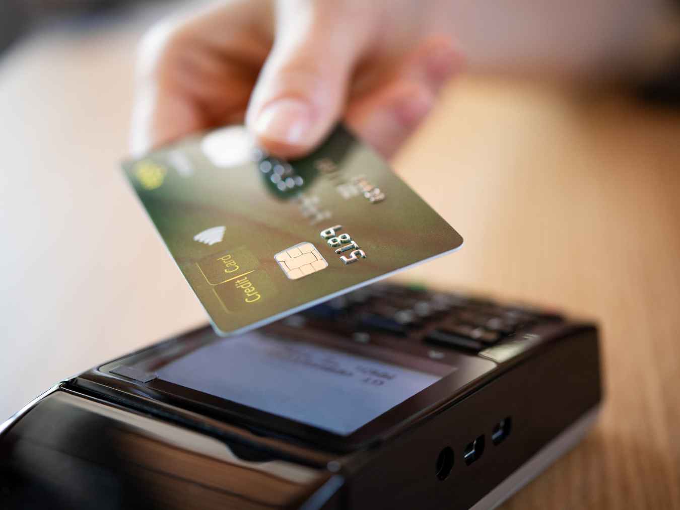 クレジットカードを非接触型決済端末にかざして支払いを行う様子
