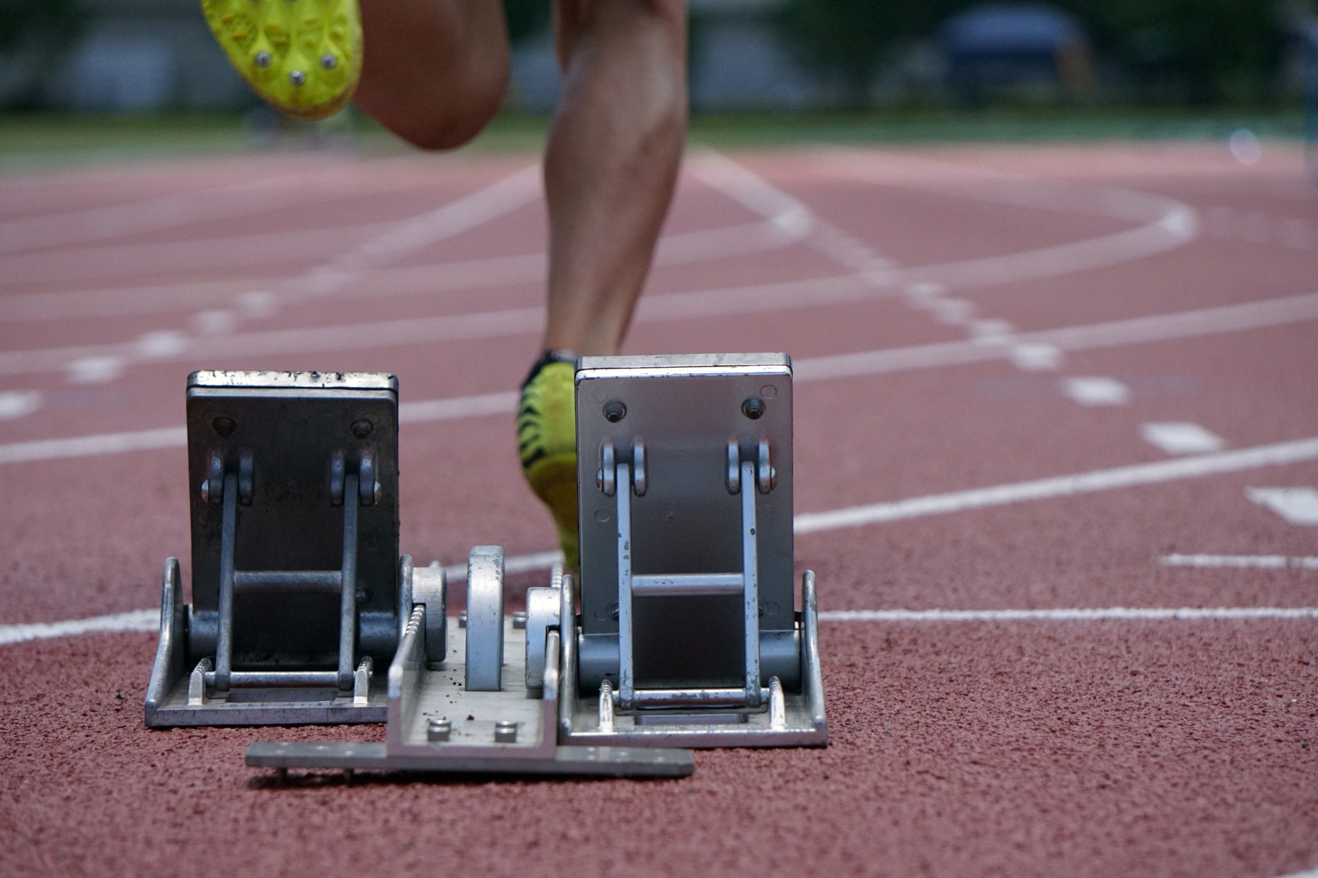 陸上トラックでスターティングブロックから飛び出すスプリンターの脚