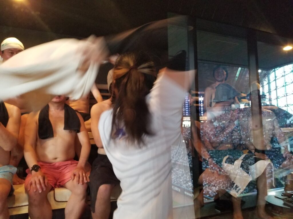 サウナ室でアウフグースを披露する五塔熱子さんと観客の様子