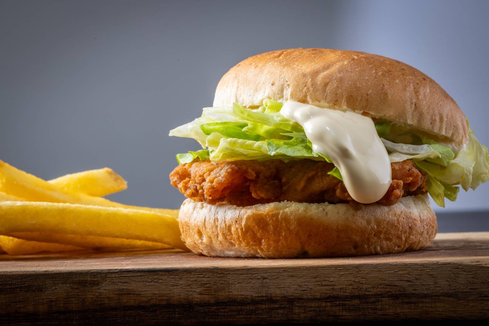 フライドチキンとレタスを挟んだタルタルソース入りのチキンバーガーとフライドポテト