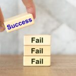 成功と失敗を表すブロックを積み重ねた手のイメージ