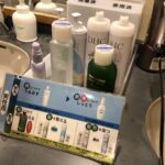 脱衣所の洗面台に並ぶDHC製の男性用スキンケアとヘアケアアメニティ