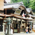 道後温泉本館の伝統的な木造建築と観光客の様子