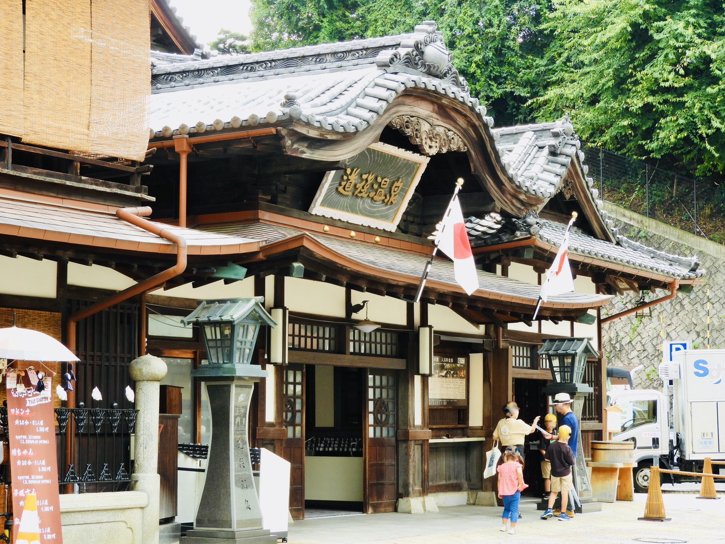 道後温泉本館の伝統的な木造建築と観光客の様子