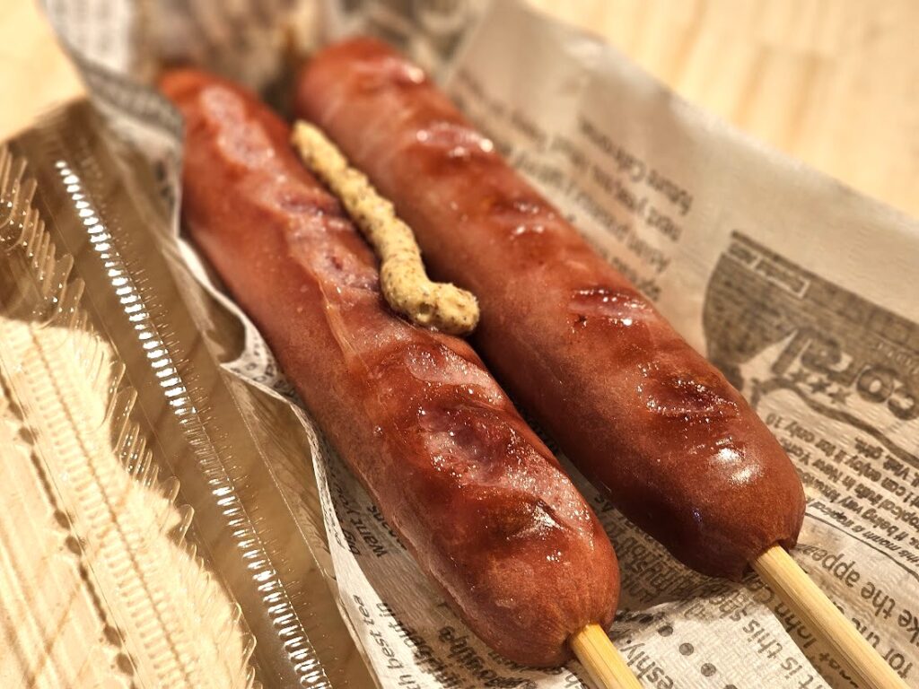 焼きソーセージ串に粒マスタードを添えた温浴施設の人気フード