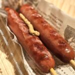 焼きソーセージ串に粒マスタードを添えた温浴施設の人気フード