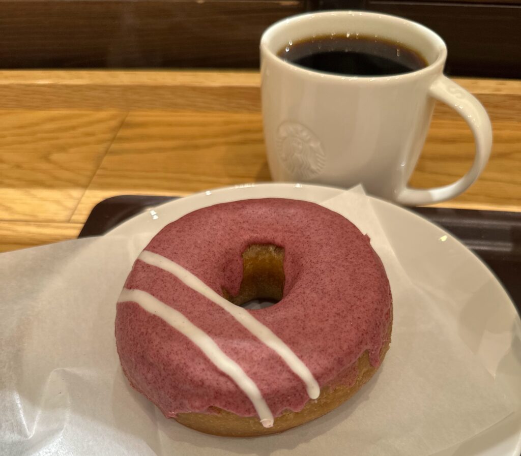 ストロベリー風味のドーナツとホットコーヒーが並ぶテーブルの様子