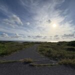 海沿いの小道と夕日が照らす穏やかな風景