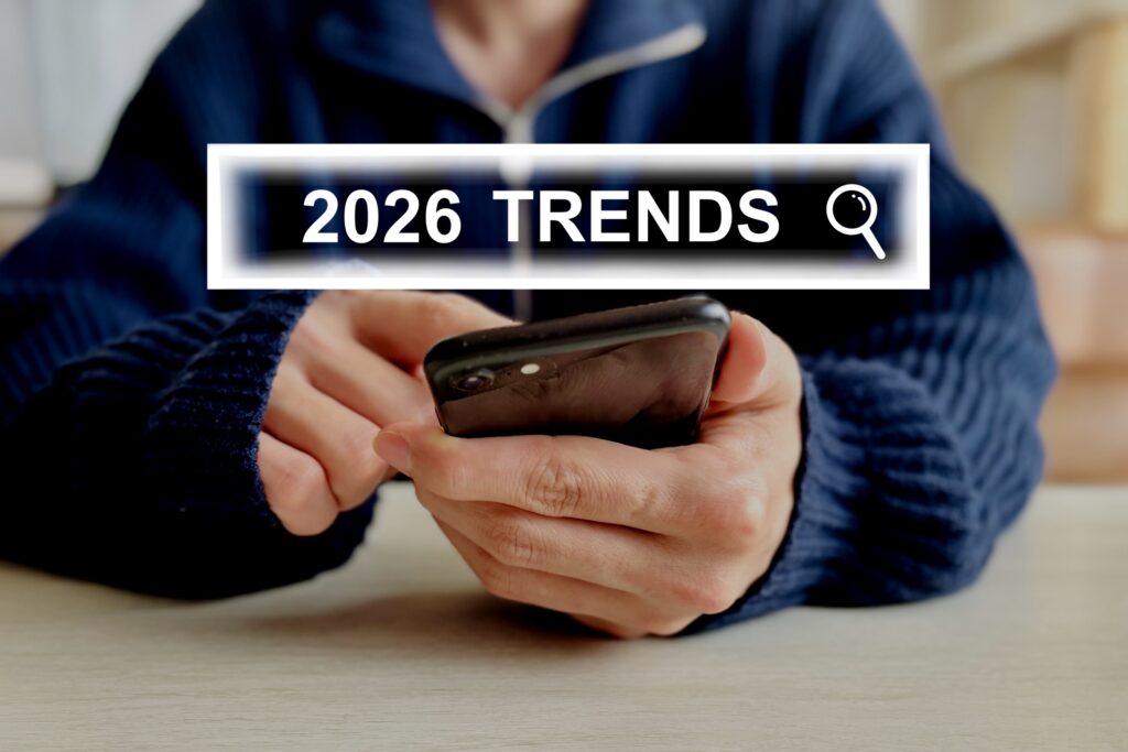 スマートフォンを操作する人物と「2026 TRENDS」の検索イメージを示す画面