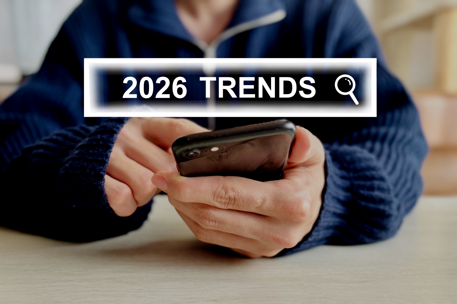 スマートフォンを操作する人物と「2026 TRENDS」の検索イメージを示す画面
