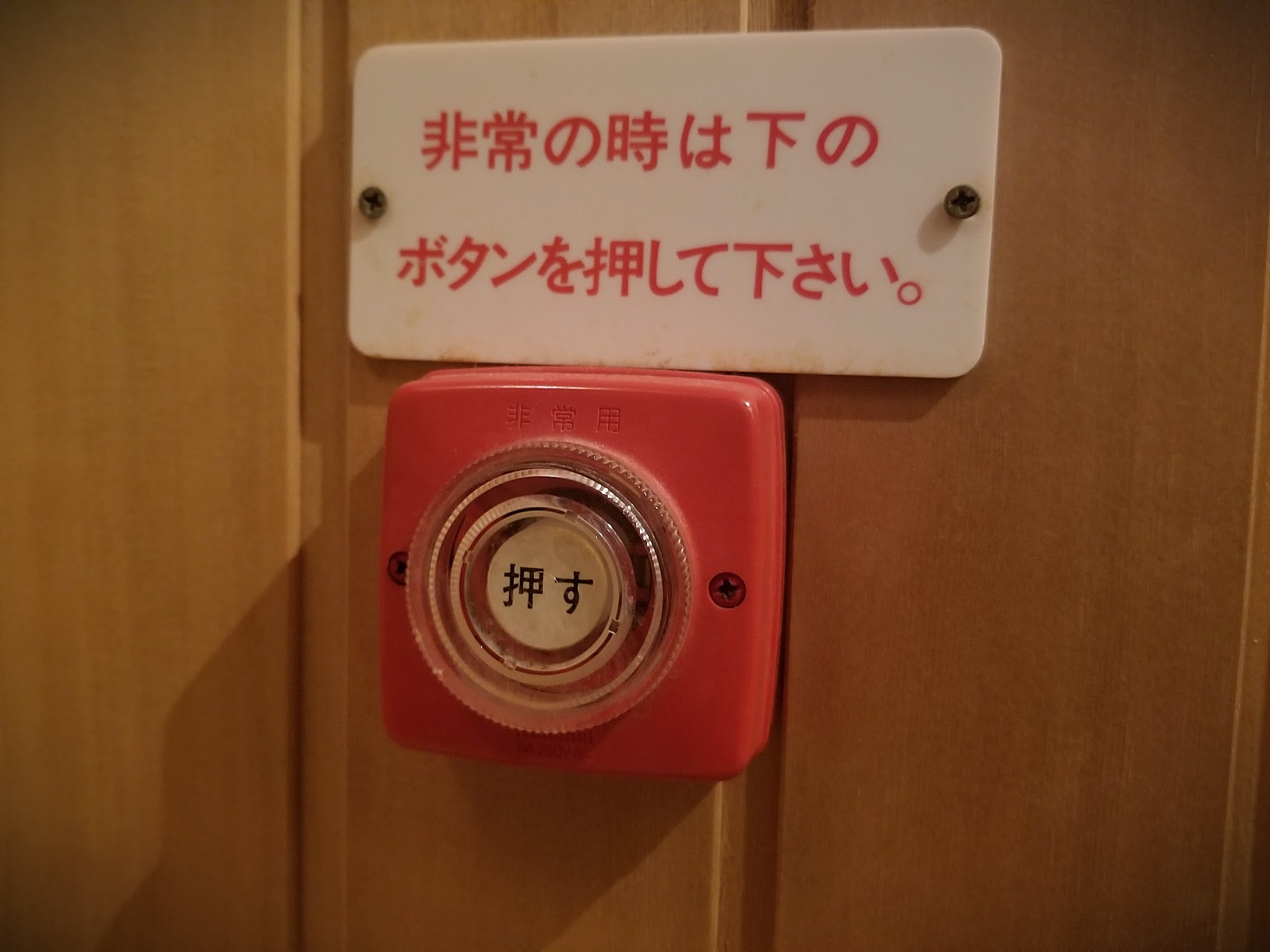 サウナ室内に設置された非常呼び出しボタンと非常時操作案内プレート