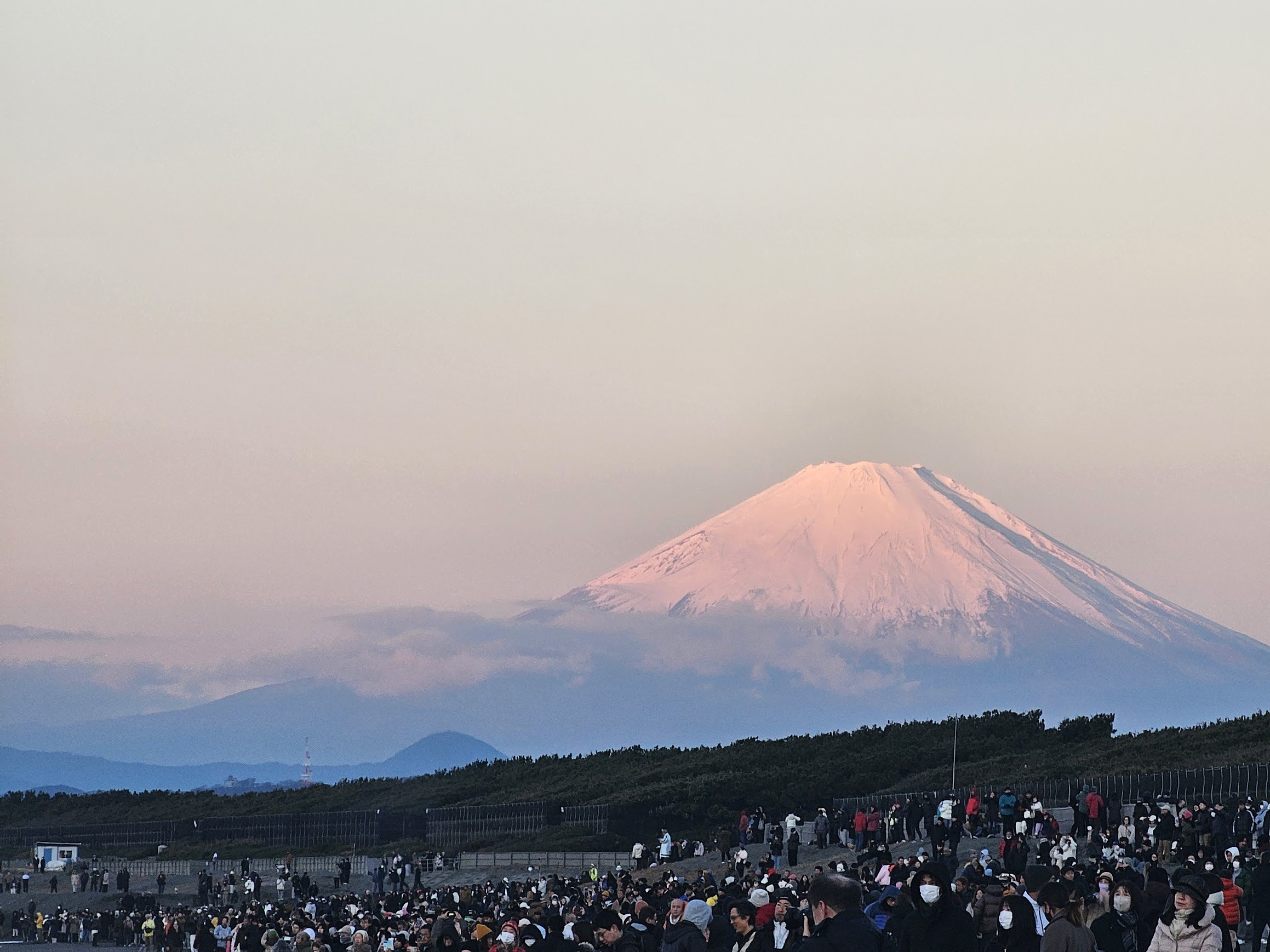 多くの人が集まる屋外広場と遠景に見える富士山を撮影した風景写真