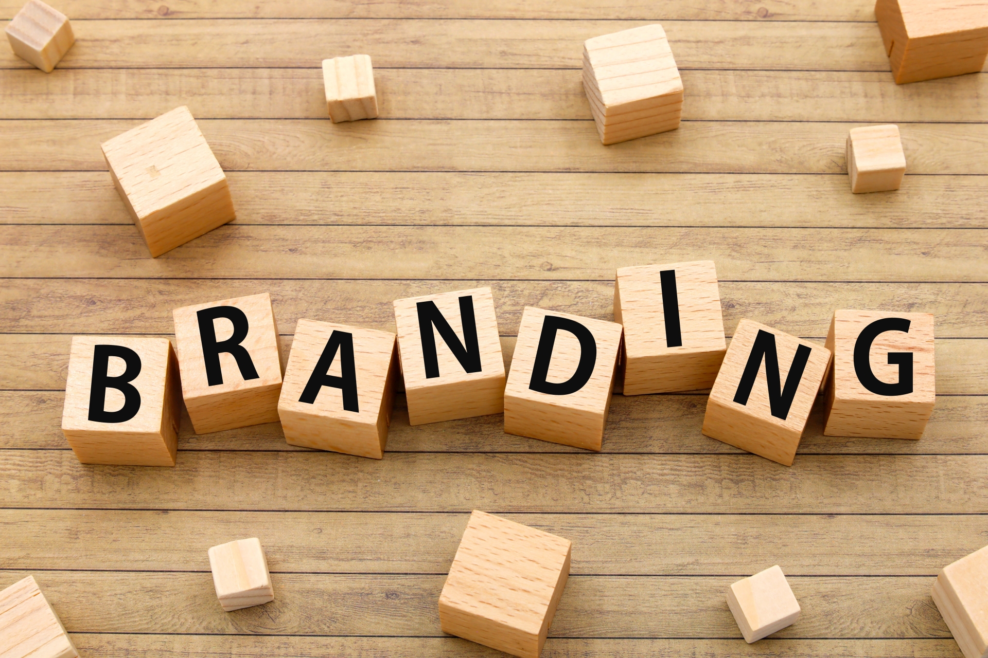 木製ブロックに「BRANDING」の文字が並べられたテーブル上の配置を示す写真です。
