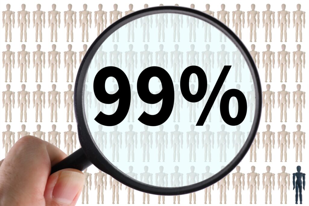 多数の人型模型が並ぶ背景の前で、拡大鏡越しに99％の数字が表示されている様子。