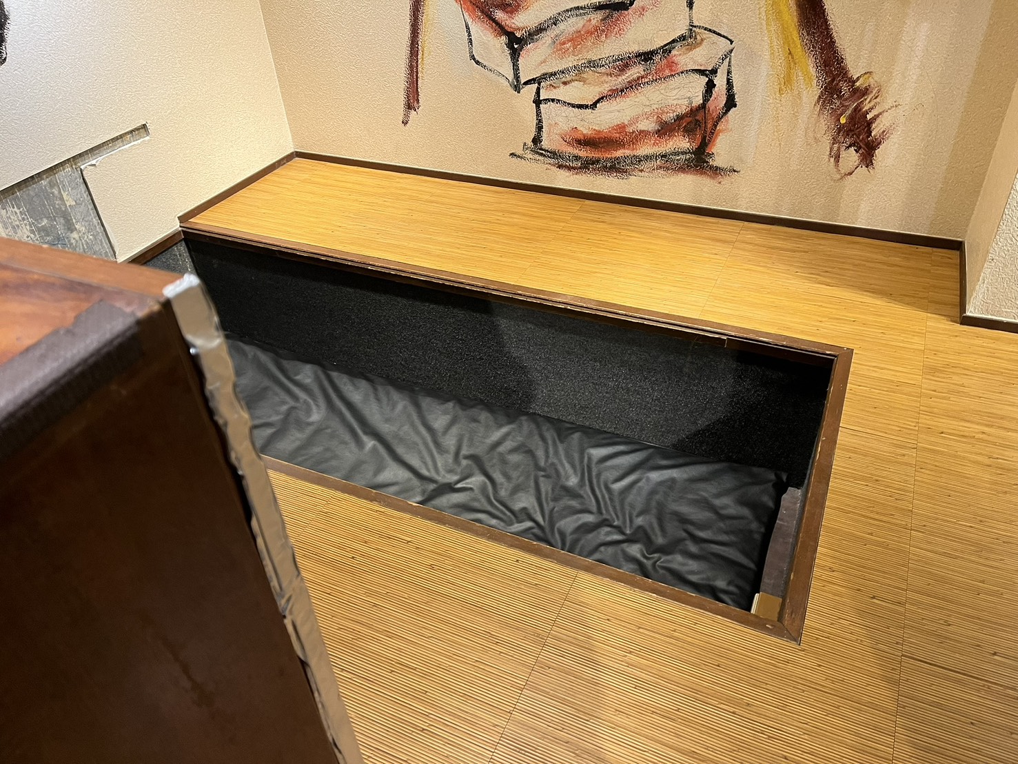 小上がり席の床に設けられた掘り炬燵跡の窪みにクッションが敷かれている様子。