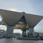 東京ビッグサイト正面入口の逆三角形構造と広場の様子を撮影した展示会会場外観の写真です。