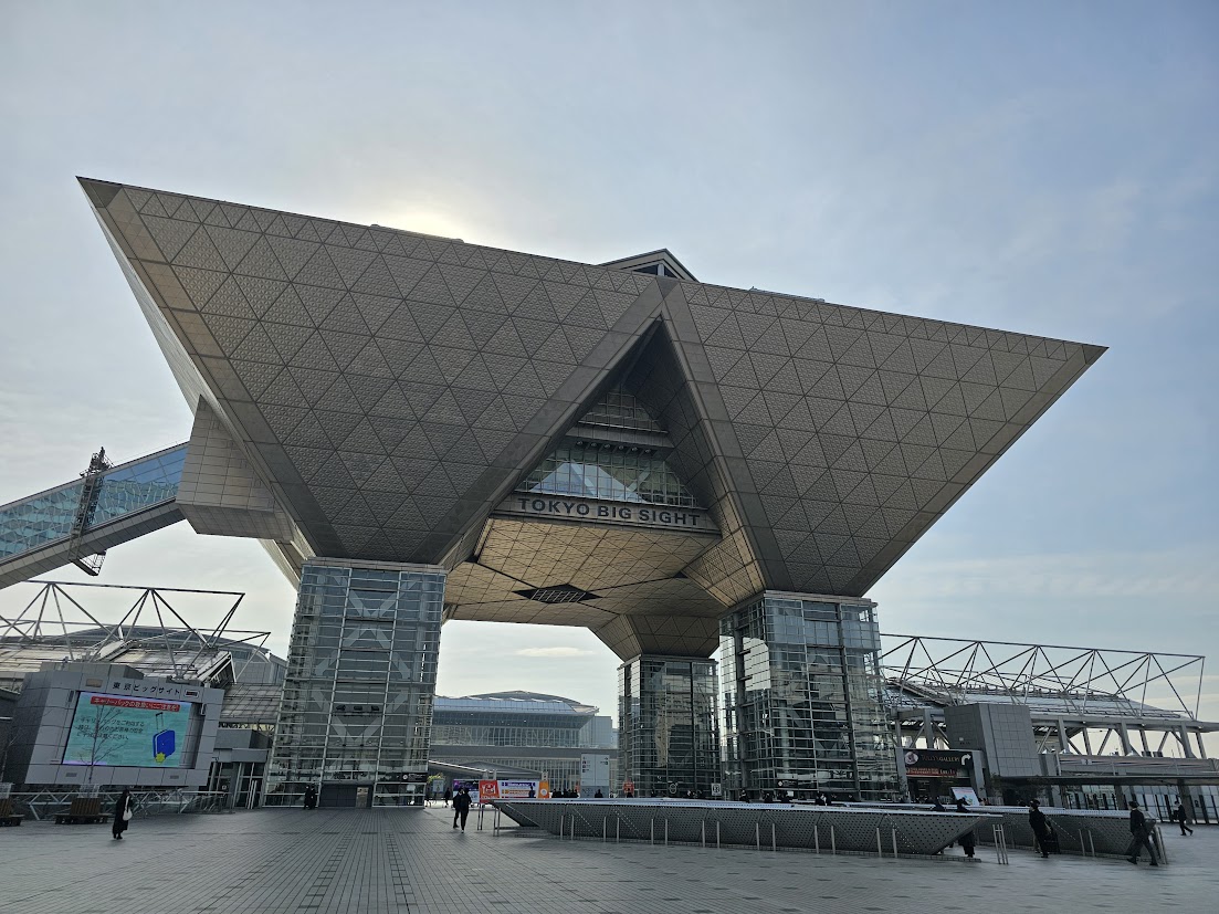 東京ビッグサイト正面入口の逆三角形構造と広場の様子を撮影した展示会会場外観の写真です。