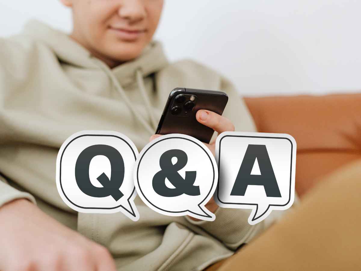 スマートフォンを操作する人物の前にQ&Aと書かれた吹き出しアイコンが配置されたSEOイメージ写真。