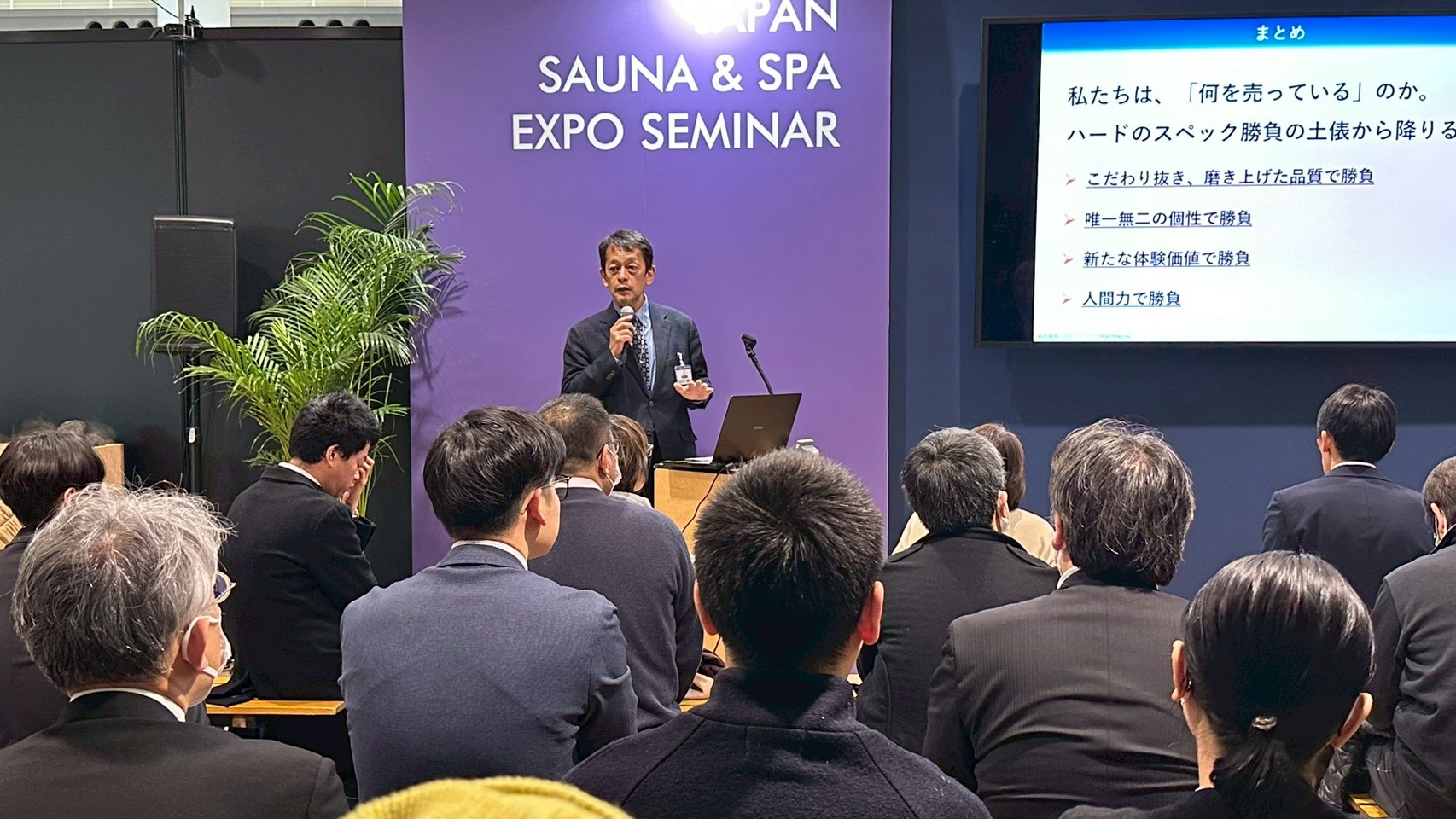 JAPAN SAUNA & SPA EXPO会場で温浴マーケット講演を行う登壇者と聴講者の様子。
