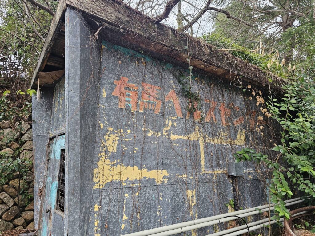 有馬温泉に残る旧有馬ヘルスセンター建物の外観で、壁面に看板跡が見える様子です。