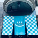 墨田区にあるサウナ施設ニューウイングの入り口に掲げられた水色と白の市松模様の暖簾