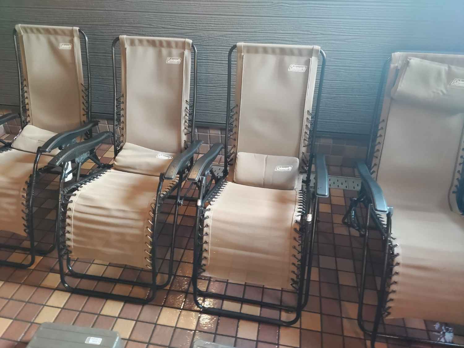 温浴施設の休憩スペースに設置された4脚のコールマン製リクライニングチェアが並んでいます。