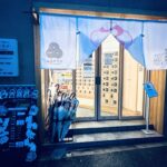 夜の時間帯の品川サウナ入口で、白い暖簾と女性専用日を知らせる看板が設置されています