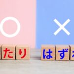 木目調のテーブルの上に、丸印とバツ印の記号が描かれた背景があり、手前にはひらがなで「あたり」「はずれ」と印字された木製のブロックが並んでいます。