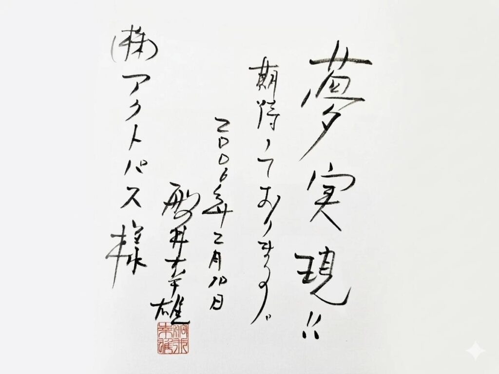 2006年2月10日の日付で株式会社アクトパス宛に贈られた「夢実現!!」と書かれた色紙の画像です。