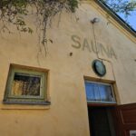 淡い黄色の外壁に「SAUNA」と書かれた、フィンランドの歴史を感じさせる伝統的な公共サウナ施設の建物