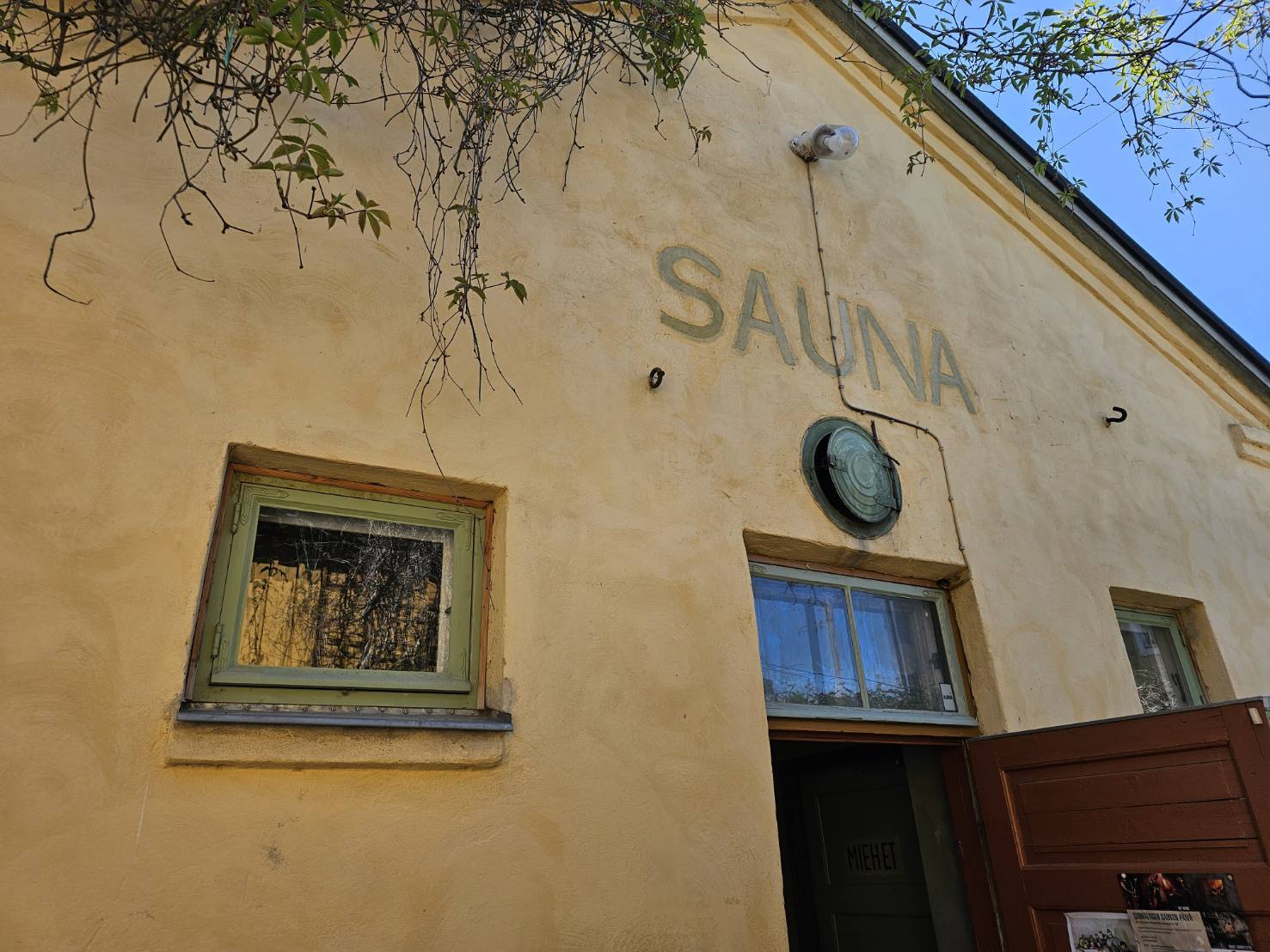 淡い黄色の外壁に「SAUNA」と書かれた、フィンランドの歴史を感じさせる伝統的な公共サウナ施設の建物