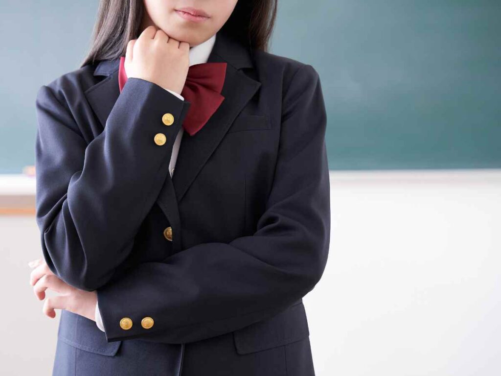 腕を組んで考え事をしている制服姿の女子高生を通して組織運営の課題を表現しています。