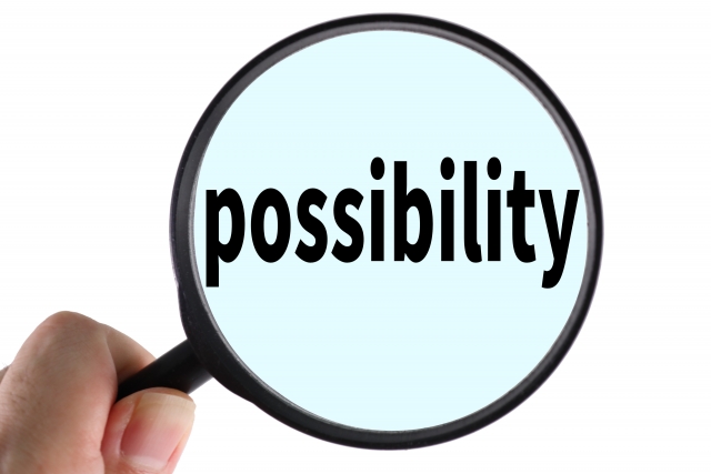 虫眼鏡で「possibility」という英単語を拡大している様子を写しています。