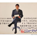スーツを着た男性が椅子に座って書類を持つ昭和期のニュージャパンサウナの広告ポスター