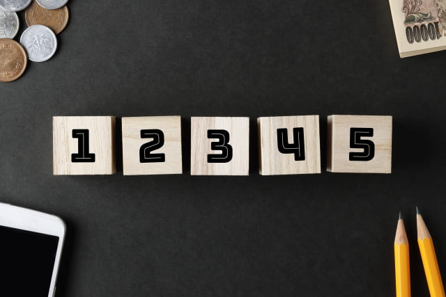 黒い背景の上に、1から5までの数字が書かれた木製のブロックが並べられている様子です。