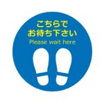 青い円形の背景に白い足跡のイラストと、「こちらでお待ち下さい」というテキストが書かれた床用の案内サインです。