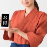 和装ユニフォームを着用したスタッフが「お得」と表示されたスマートフォン画面を両手で提示しています