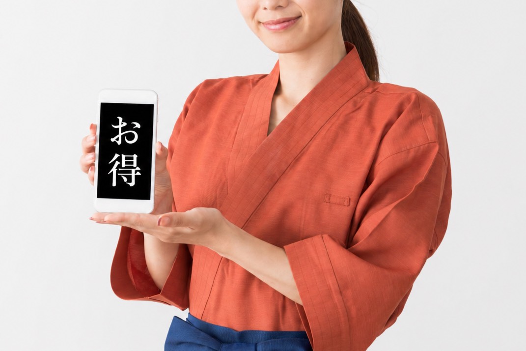 和装ユニフォームを着用したスタッフが「お得」と表示されたスマートフォン画面を両手で提示しています