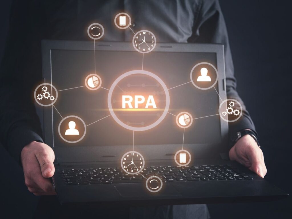 ノートパソコンを持つ人物の手元とRPAやデータ処理を表すネットワークアイコンのグラフィックが表示されています