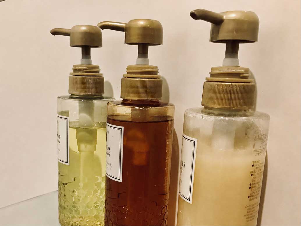 温浴施設やサウナの浴室で使用されるシャンプーなどのアメニティボトルが3本並んでいます