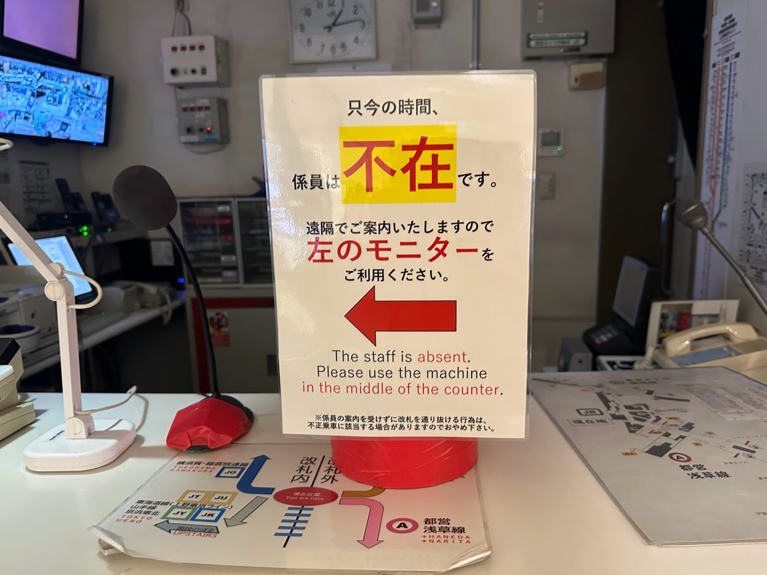 駅の改札窓口カウンターに、係員不在と遠隔案内モニターの利用を促す案内POPが設置されています。
