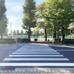 街路樹が並ぶ公園前の道路に白い横断歩道が引かれている、スタッフへの伝え方を考える記事の写真です