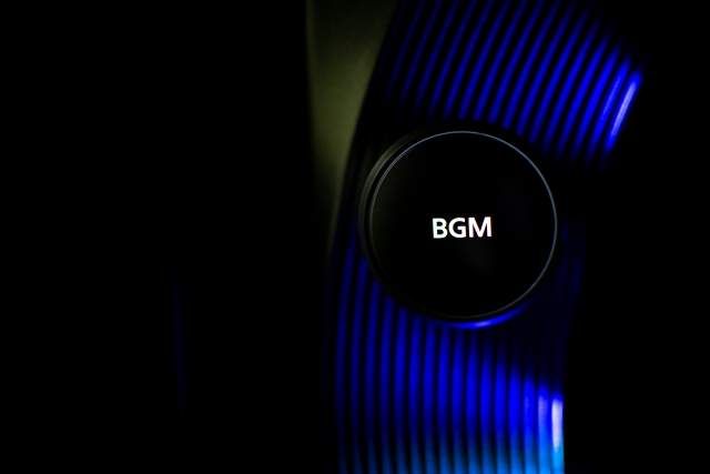 青い光が灯る音響機器にBGMと書かれた音量調節ノブが写っています。