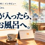 露天風呂を望む温浴施設の休憩スペースで、木のテーブルに漫画本と卓上カレンダー、湯のみが置かれています